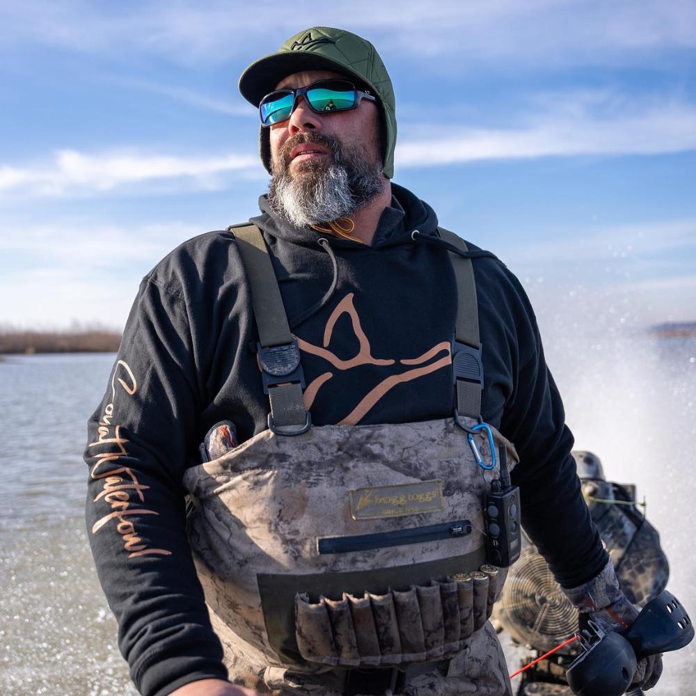 Hunter wearing Combat Waterfowl's performance hunting hoodie in action, blending seamlessly into the outdoor environment.