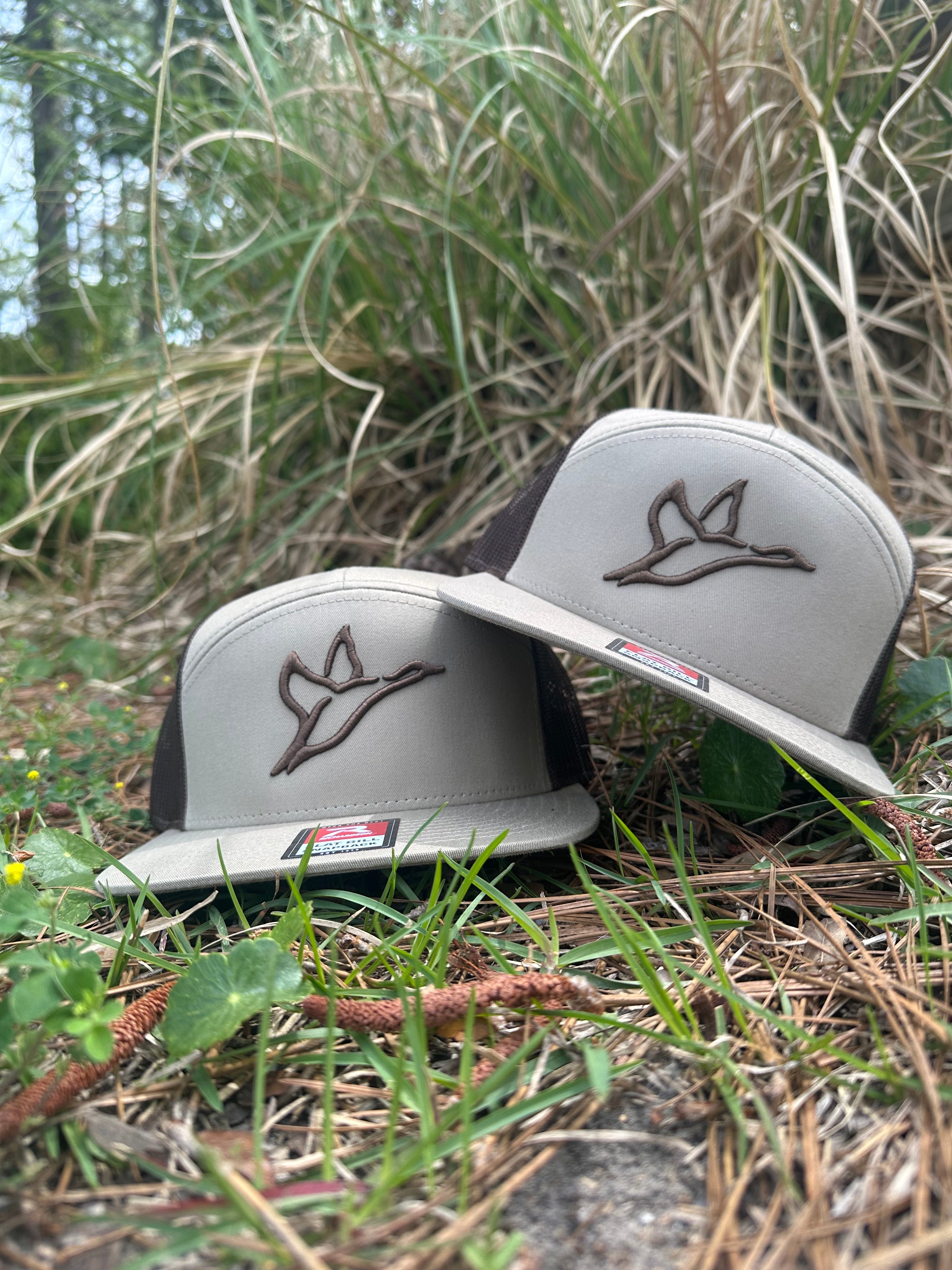 Two Richardson 168 brown khaki trucker hats with 3D puff embroidered duck logos on tan panels.