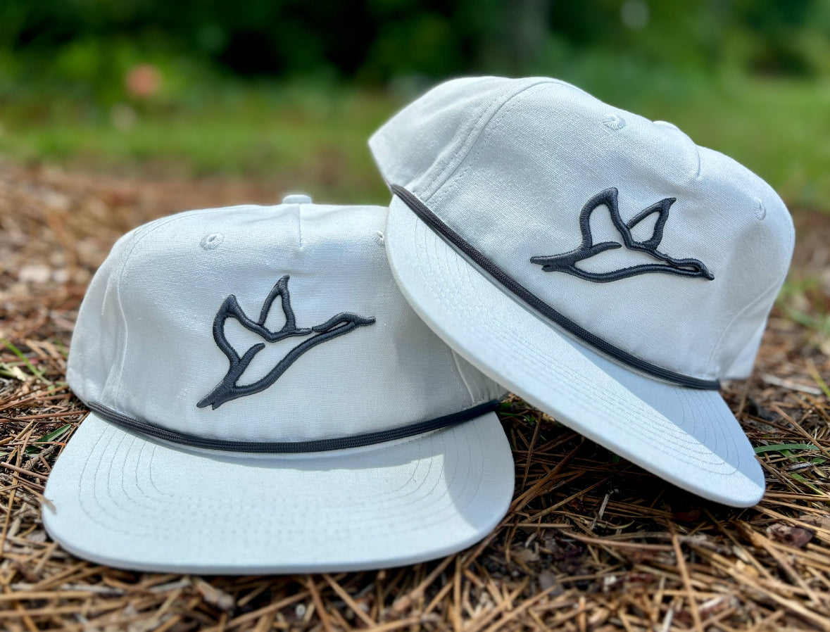 Two white Goat Rope™ Salt embroidered rope hats with a black flying duck logo and black rope detail.